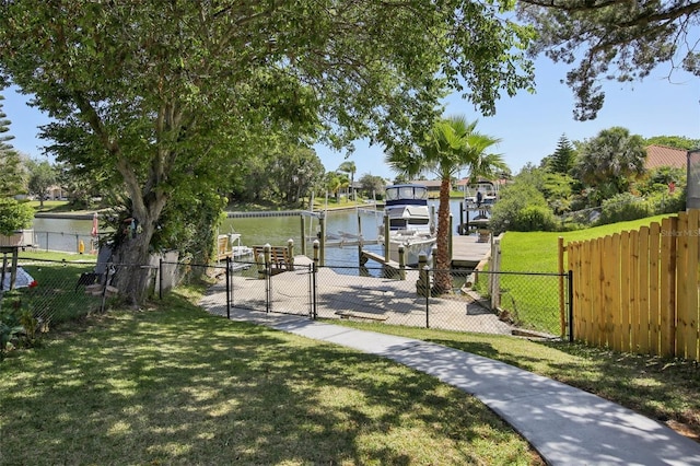 view of dock featuring fence, boat lift, a gate, a lawn, and a water view