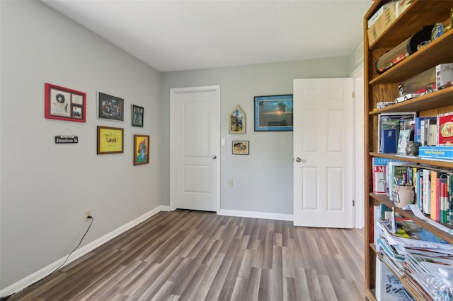 interior space featuring baseboards and wood finished floors