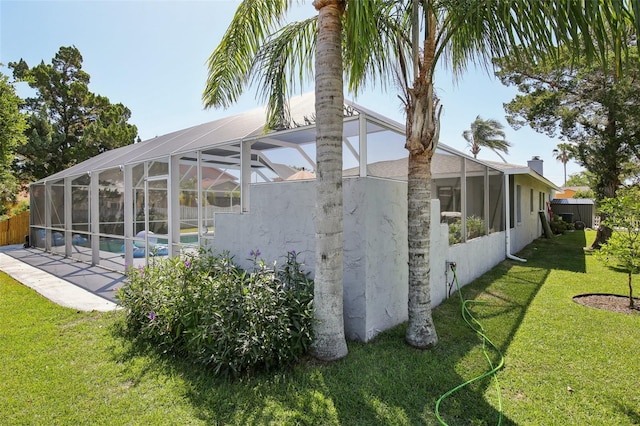 view of property exterior with a lawn, an outdoor pool, glass enclosure, fence, and stucco siding