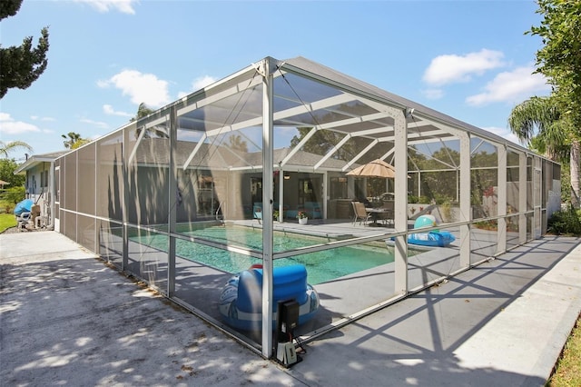 pool with glass enclosure and a patio