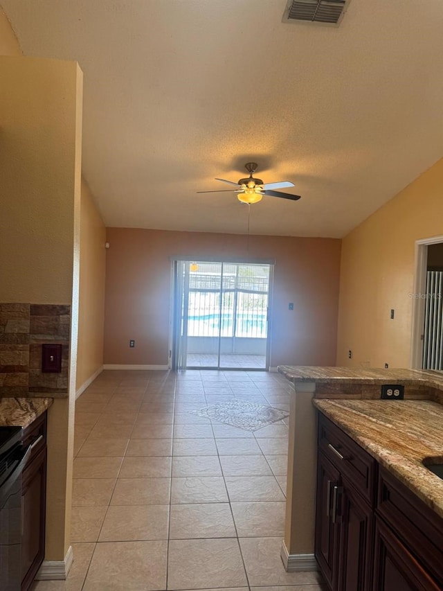 1621 Emily Ct, Kissimmee, FL 34744 - kitchen featuring ceiling fan, light tile patterned flooring, light stone countertops, and open floor plan