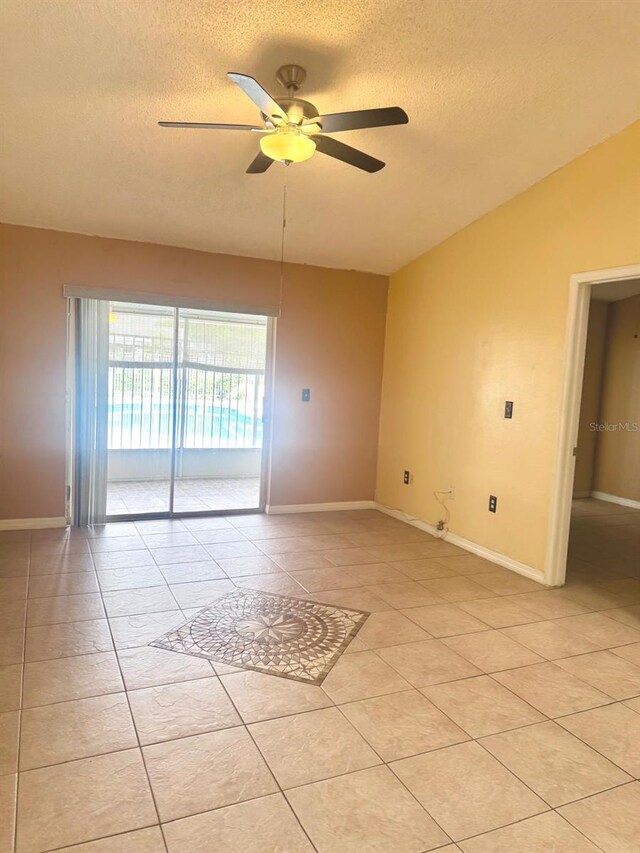 1621 Emily Ct, Kissimmee, FL 34744 - empty room featuring ceiling fan, a textured ceiling, light tile patterned floors, and lofted ceiling