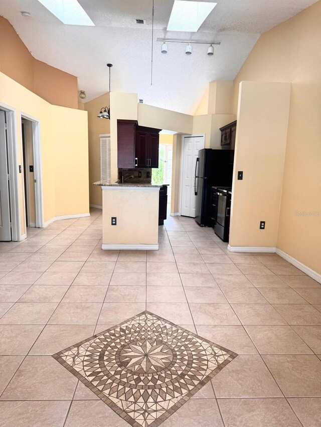 1621 Emily Ct, Kissimmee, FL 34744 - kitchen featuring a skylight, light tile patterned floors, stove, freestanding refrigerator, and high vaulted ceiling