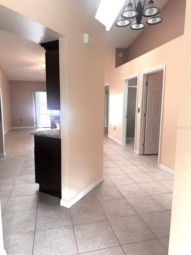 1621 Emily Ct, Kissimmee, FL 34744 - corridor with light tile patterned flooring, a chandelier, and vaulted ceiling