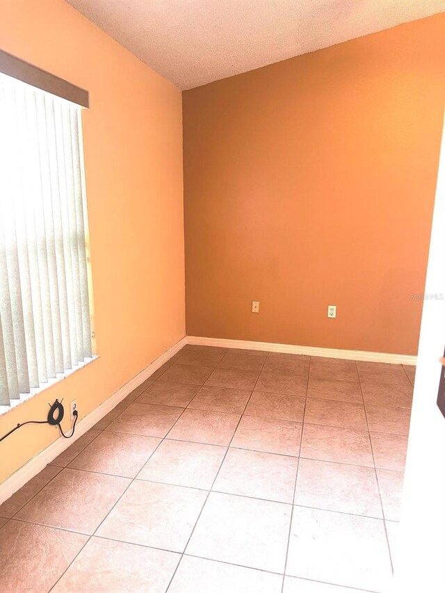 1621 Emily Ct, Kissimmee, FL 34744 - tiled spare room with a textured ceiling and baseboards