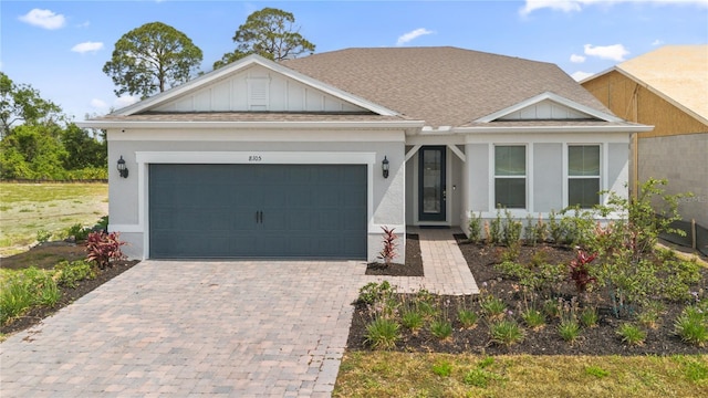 8105 Fenton St, Orlando, FL 32836 - view of front facade featuring decorative driveway, a garage, board and batten siding, and a shingled roof