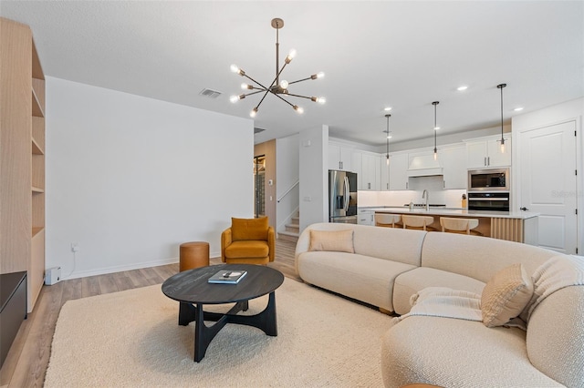8105 Fenton St, Orlando, FL 32836 - living area with light wood finished floors, stairs, a chandelier, recessed lighting, and baseboards