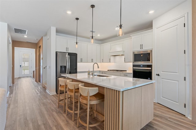 8105 Fenton St, Orlando, FL 32836 - kitchen with stainless steel appliances, a sink, premium range hood, light wood finished floors, and recessed lighting
