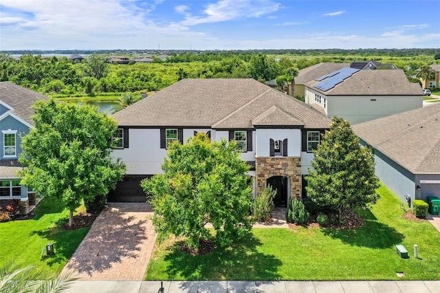 408 Egret Place Dr, Winter Garden, FL 34787 - view of front of home featuring a shingled roof, stucco siding, an attached garage, decorative driveway, and stone siding