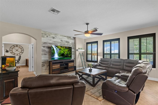 408 Egret Place Dr, Winter Garden, FL 34787 - living room with arched walkways, ceiling fan, a textured ceiling, baseboards, and light tile patterned floors