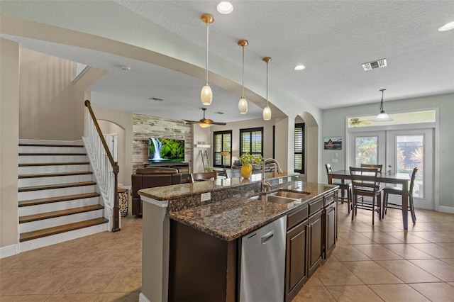 408 Egret Place Dr, Winter Garden, FL 34787 - kitchen with a sink, arched walkways, dark brown cabinetry, light tile patterned floors, and open floor plan