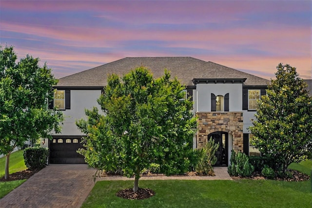 408 Egret Place Dr, Winter Garden, FL 34787 - view of front of property with stone siding, stucco siding, decorative driveway, a yard, and a shingled roof