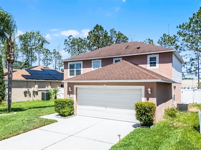 traditional-style home featuring driveway, a front yard, an attached garage, a shingled roof, and stucco siding