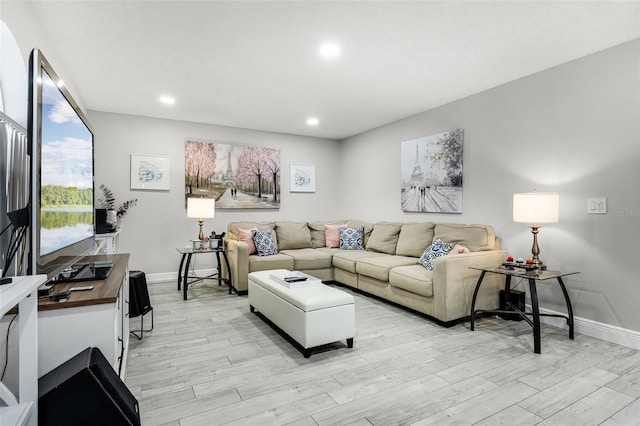 living area with recessed lighting, baseboards, and light wood-type flooring