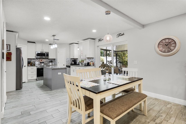 dining space featuring light wood-type flooring, recessed lighting, baseboards, and beam ceiling
