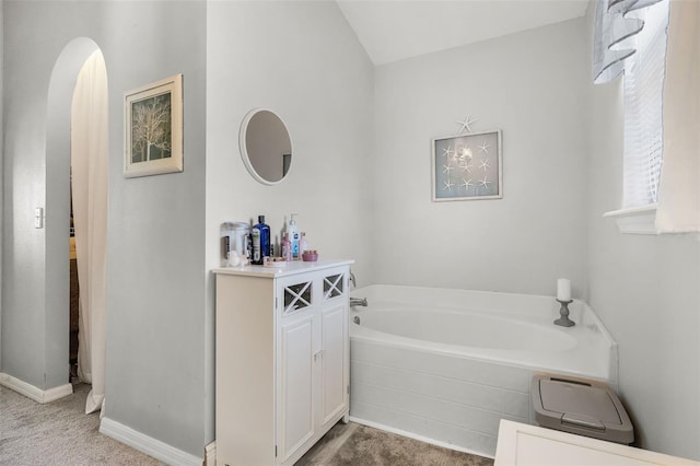 bathroom with baseboards and a bath