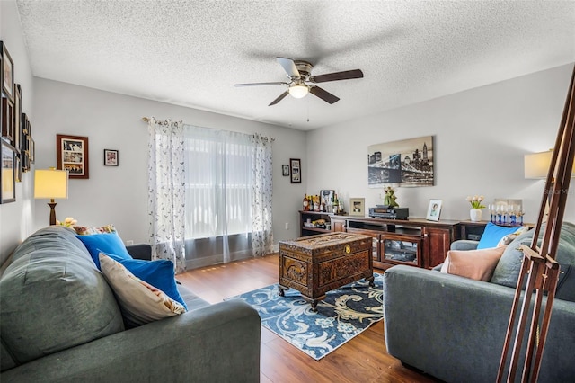 living room featuring a textured ceiling, a ceiling fan, and wood finished floors