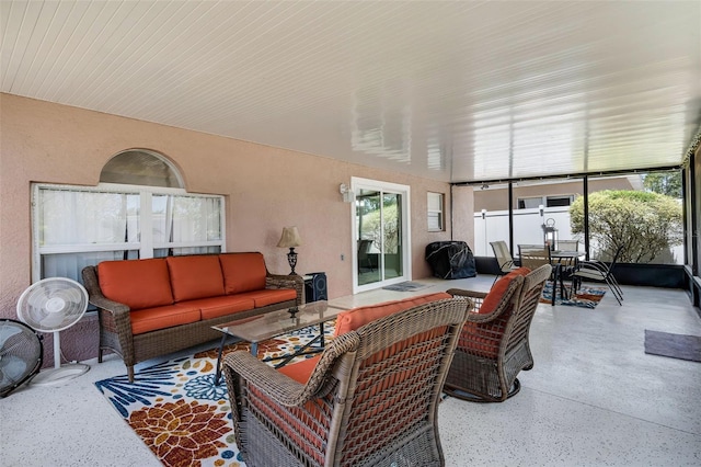 sunroom / solarium with outdoor dining space, speckled floor, and an outdoor hangout area