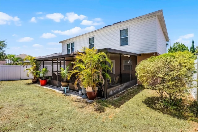 back of house with a yard, fence, and a sunroom