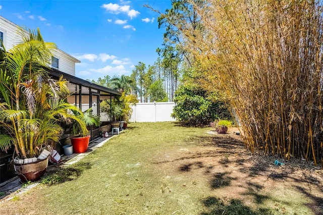 view of yard featuring fence and a sunroom