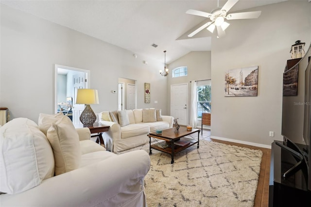 living area featuring visible vents, wood finished floors, baseboards, ceiling fan, and high vaulted ceiling