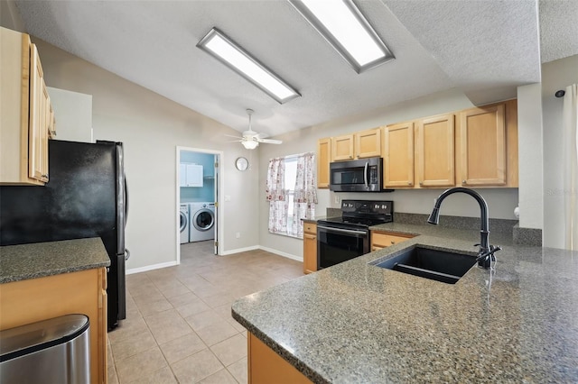 kitchen featuring light brown cabinetry, a sink, freestanding refrigerator, stainless steel microwave, and black / electric stove