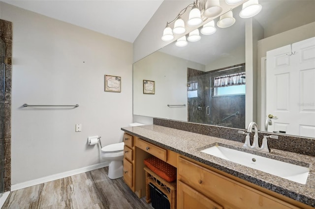 full bathroom featuring vanity, toilet, baseboards, a shower stall, and wood finished floors