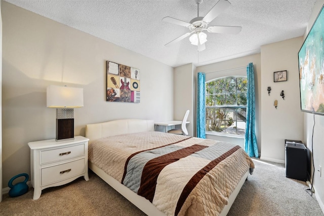 bedroom featuring a ceiling fan, a textured ceiling, and light carpet