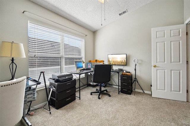 office space with carpet flooring, ceiling fan, a textured ceiling, baseboards, and visible vents