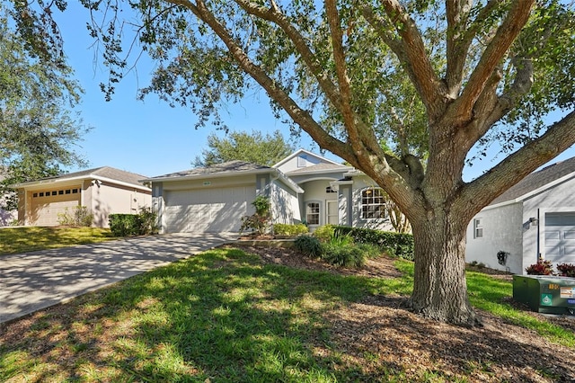 view of front of home featuring a garage, concrete driveway, and a front yard