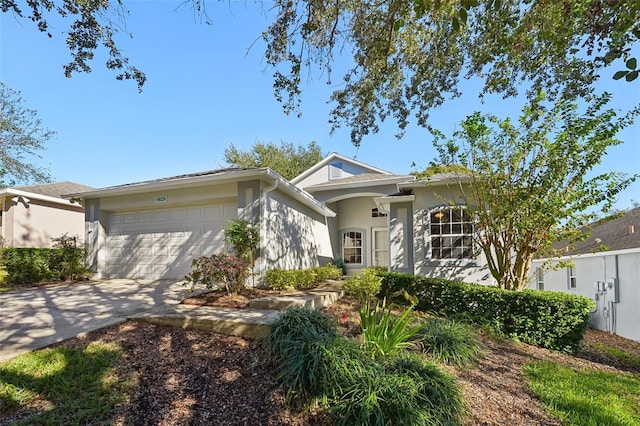 single story home with stucco siding, concrete driveway, and a garage
