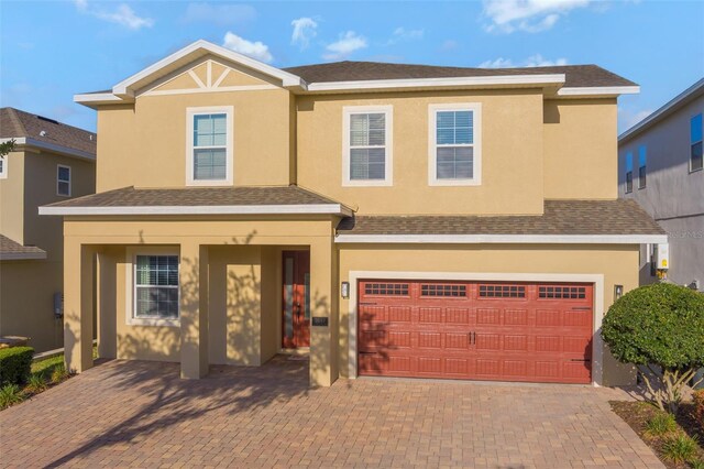 7643 Wilmington Loop, Kissimmee, FL 34747 - view of front facade featuring stucco siding, a garage, and decorative driveway