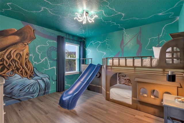 7643 Wilmington Loop, Kissimmee, FL 34747 - bedroom featuring a textured ceiling, a chandelier, and wood finished floors