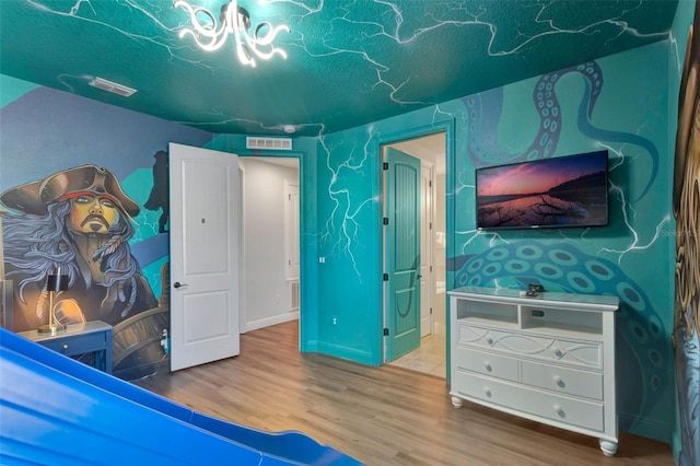 7643 Wilmington Loop, Kissimmee, FL 34747 - bedroom featuring a textured ceiling, a notable chandelier, visible vents, and wood finished floors