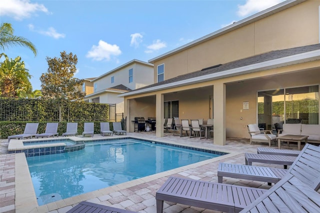 7643 Wilmington Loop, Kissimmee, FL 34747 - view of swimming pool with outdoor dining space, fence, a pool with connected hot tub, an outdoor hangout area, and a patio area