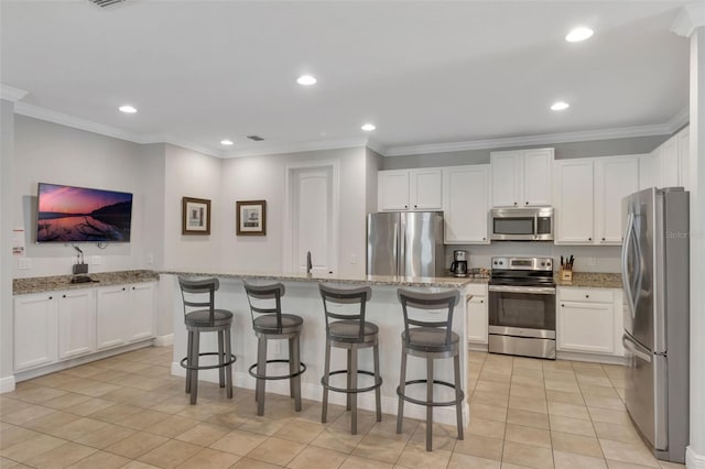 7643 Wilmington Loop, Kissimmee, FL 34747 - kitchen featuring light tile patterned floors, crown molding, white cabinetry, appliances with stainless steel finishes, and recessed lighting