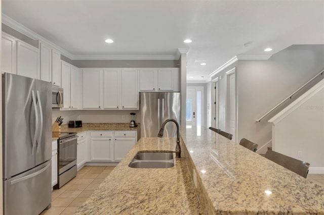 7643 Wilmington Loop, Kissimmee, FL 34747 - kitchen with ornamental molding, light stone counters, a sink, white cabinets, and appliances with stainless steel finishes