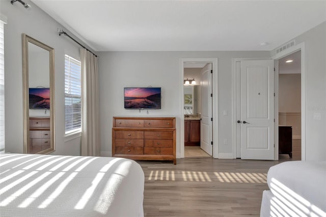 7643 Wilmington Loop, Kissimmee, FL 34747 - bedroom with connected bathroom, baseboards, visible vents, and light wood-style floors
