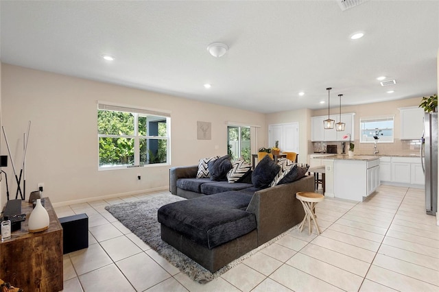 living area with light tile patterned floors, recessed lighting, visible vents, and plenty of natural light