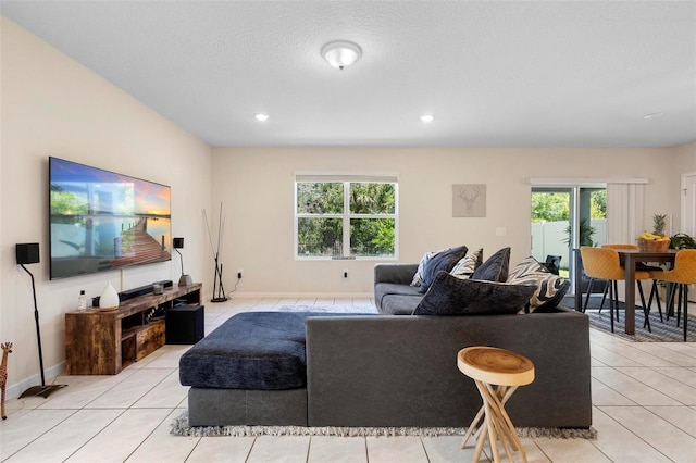 living area featuring baseboards, light tile patterned floors, and plenty of natural light