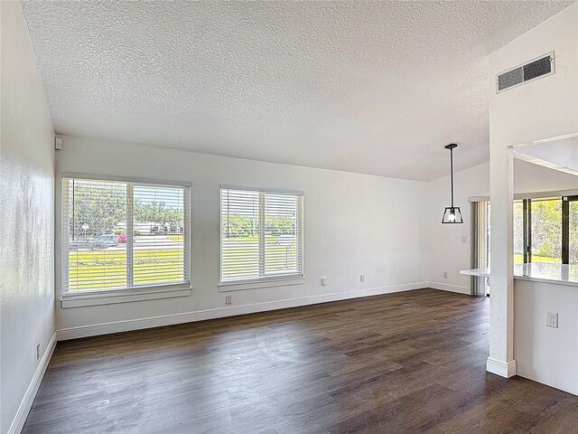 857 E Flag Ln, Kissimmee, FL 34759 - unfurnished room with a textured ceiling, baseboards, visible vents, and dark wood finished floors