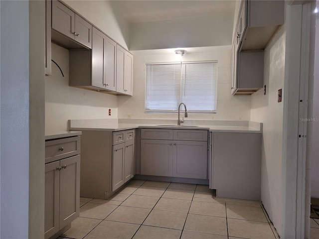 936 Pinedale Ave, Orlando, FL 32808 - kitchen with light tile patterned floors, gray cabinetry, and a sink