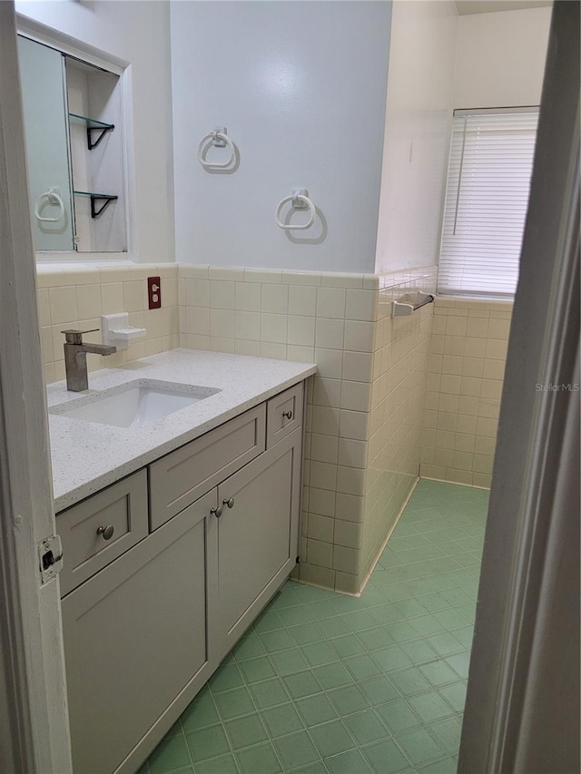 936 Pinedale Ave, Orlando, FL 32808 - bathroom with tile walls, tile patterned floors, vanity, and a wainscoted wall