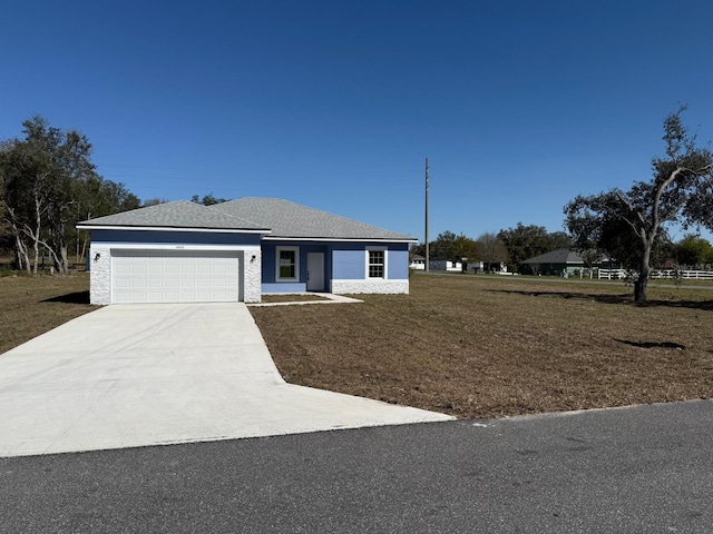 ranch-style home featuring a garage, driveway, and a front yard