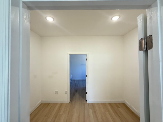 empty room featuring baseboards, recessed lighting, and light wood finished floors