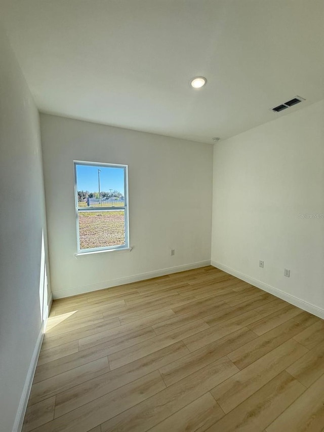 empty room with recessed lighting, baseboards, visible vents, and light wood-type flooring