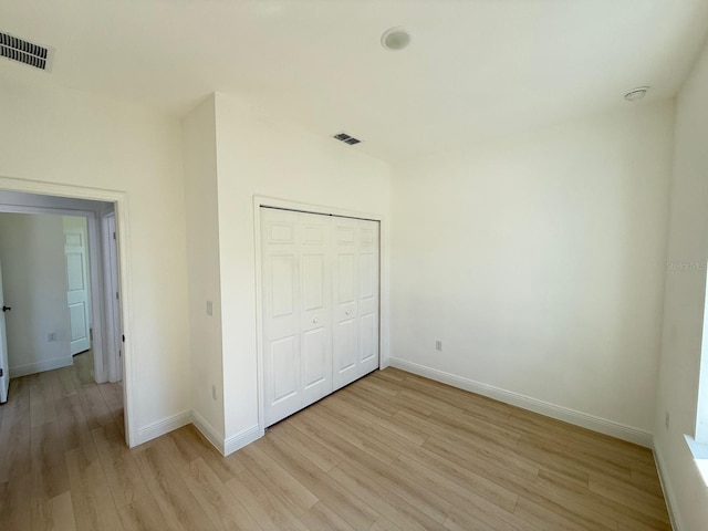 unfurnished bedroom with baseboards, visible vents, and light wood finished floors