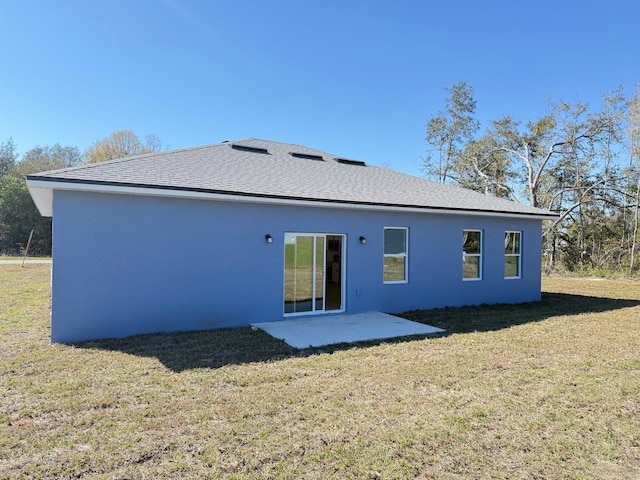 rear view of house with a patio, stucco siding, and a yard