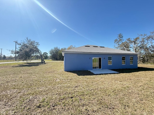 back of house featuring a patio, stucco siding, and a yard