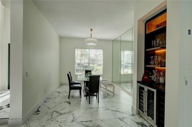dining room with a dry bar, baseboards, marble finish floor, a notable chandelier, and wine cooler